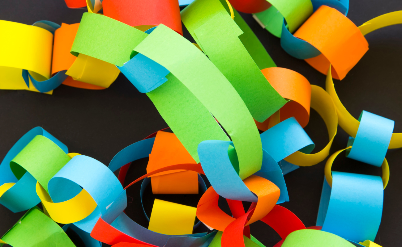A pile of paper chains made from linking small strips of colour paper.
