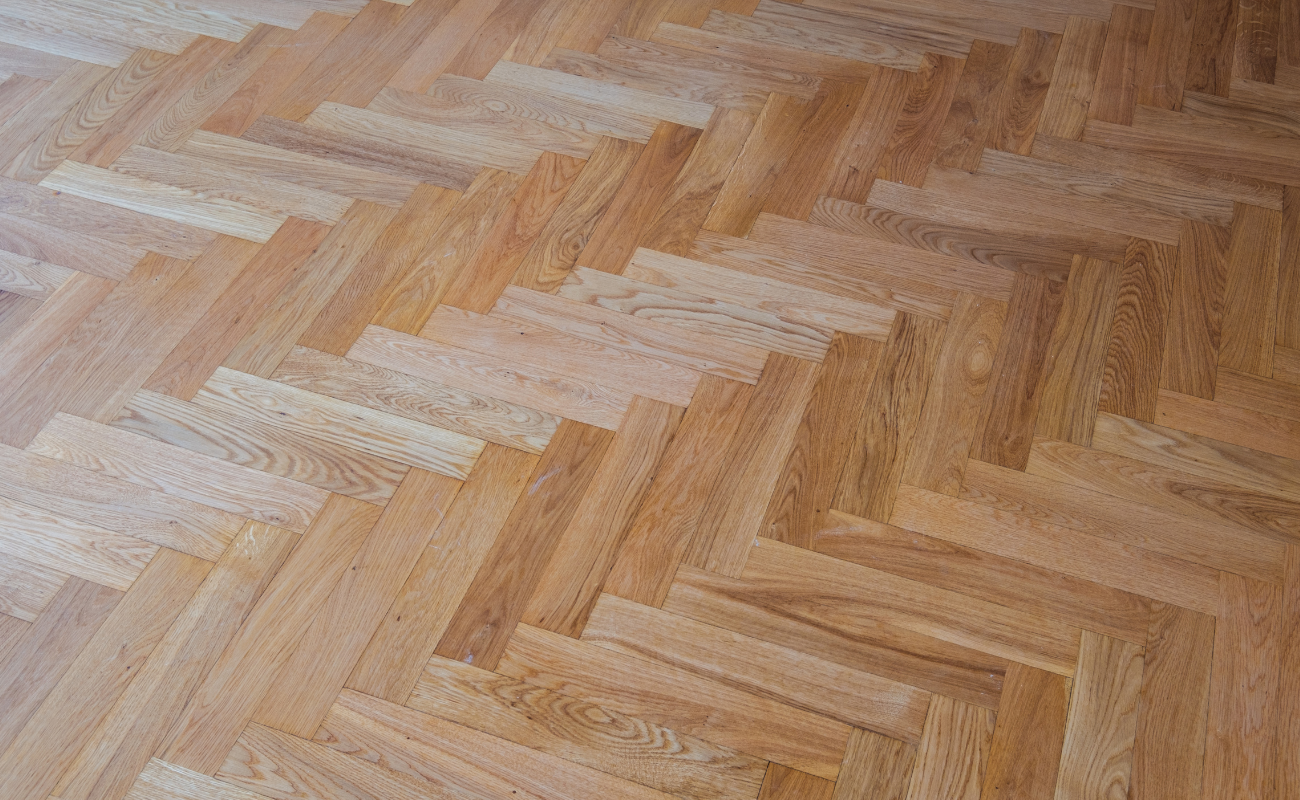 A photograph of wooden flooring. The pieces are placed in a repeating pattern.